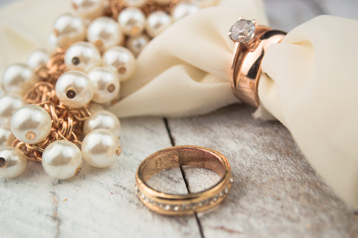 Golden wedding rings on white wood background