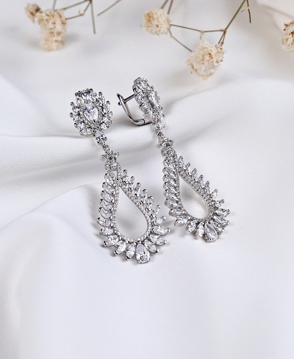 A pair of silver drop earrings with diamonds
