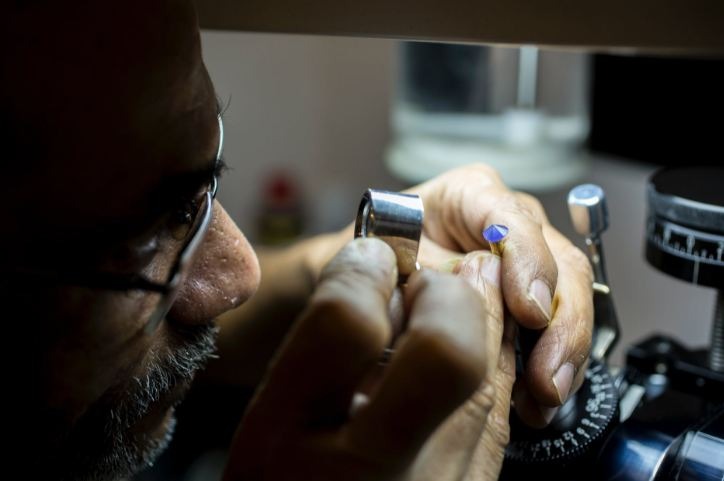 A gemologist examining a gem under a magnifying glass