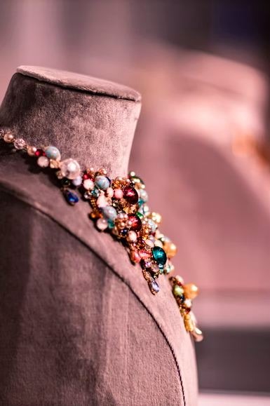 A necklace of colorful gemstones on a mannequin