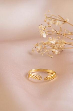 Picture of a ring and some flowers on a pink fabric cloth