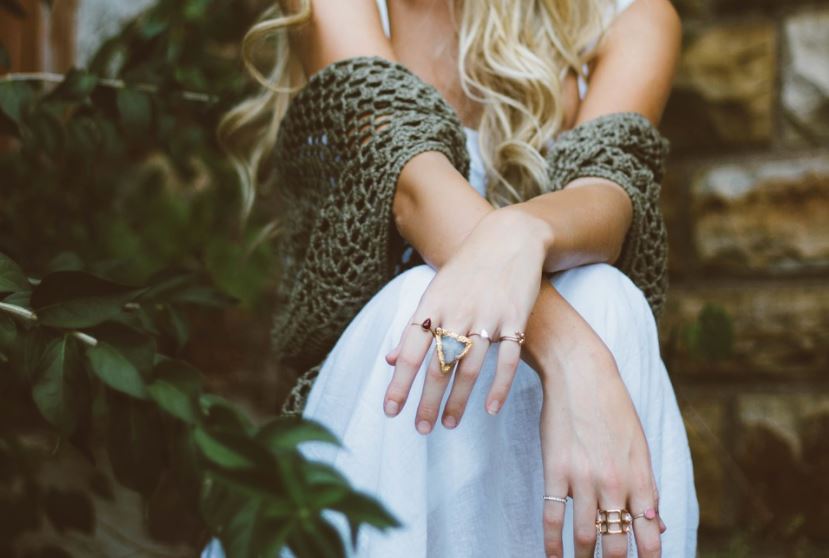 a woman with blonde shawl rings