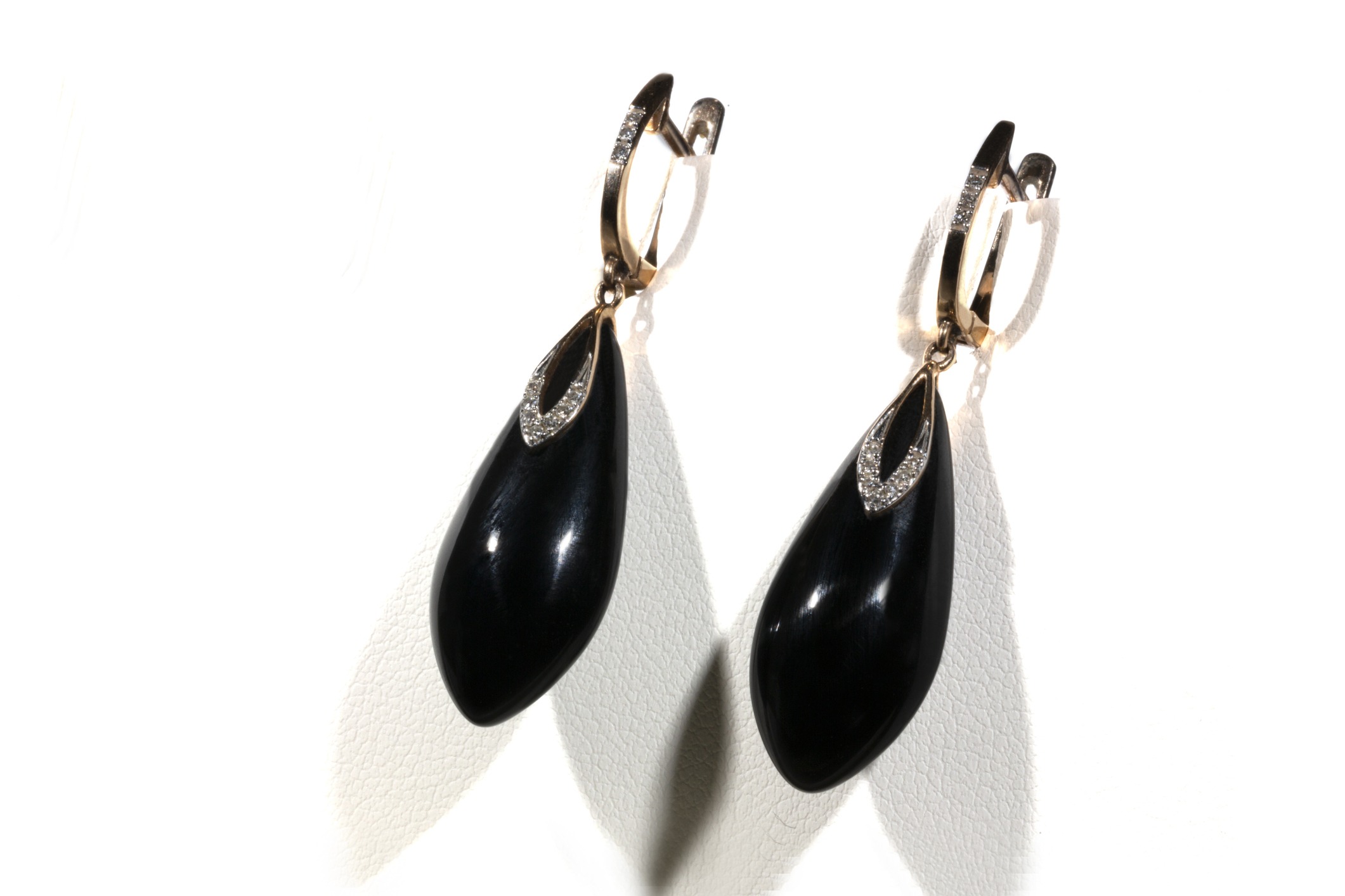 gold earrings with onyx and diamonds on a white background. Long earrings. women's accessories