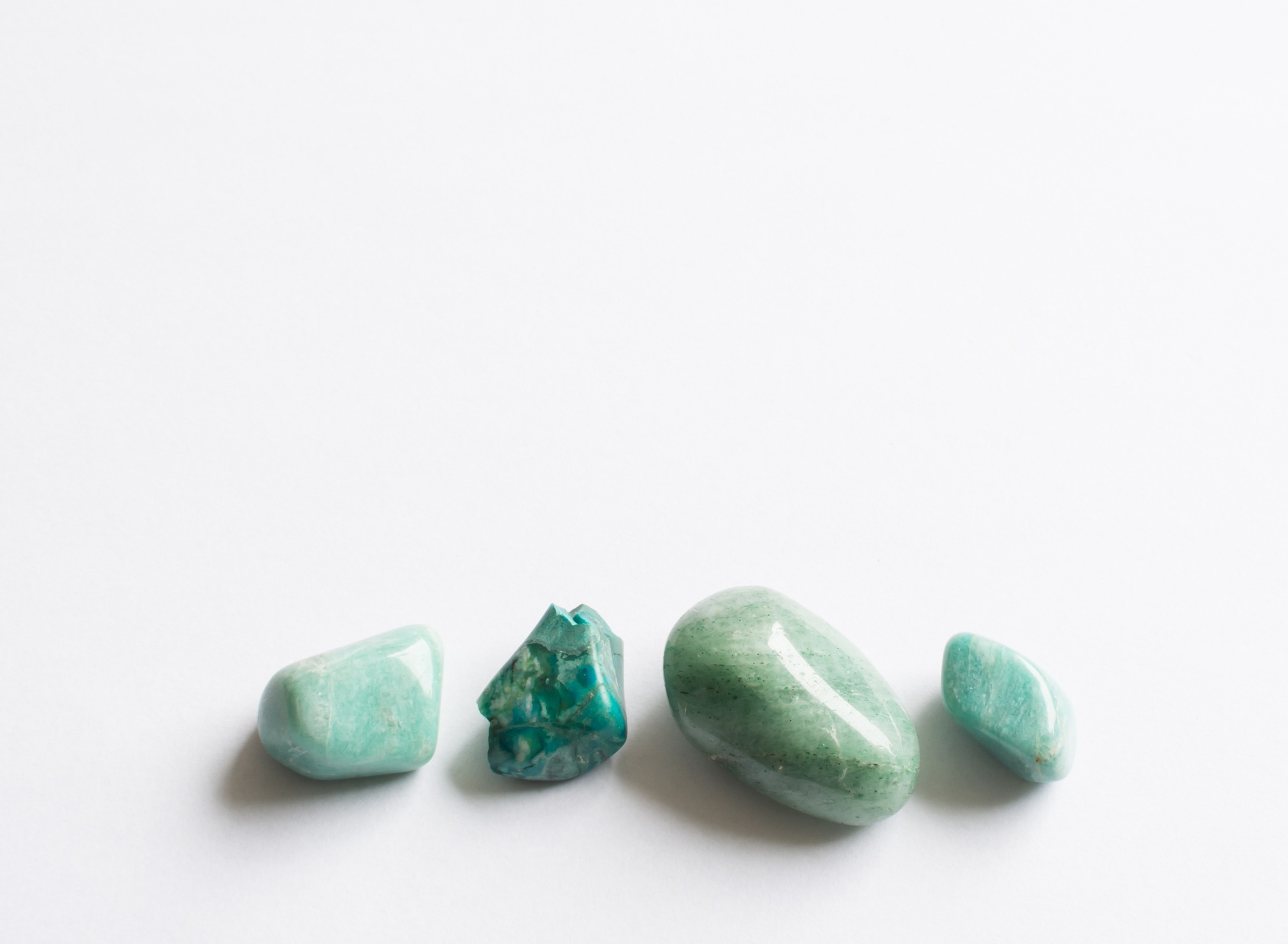 Four green semi-precious stones. Turquoise, aventurine, amazonite on white background.
